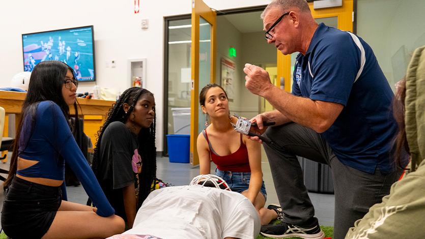 Image of students learning about athletic emergency health procedures during a Pre-Health class at Summer Pre-College. 